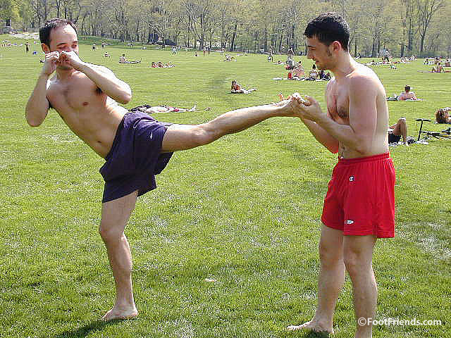 Guys posing on camera barefoot in shorts