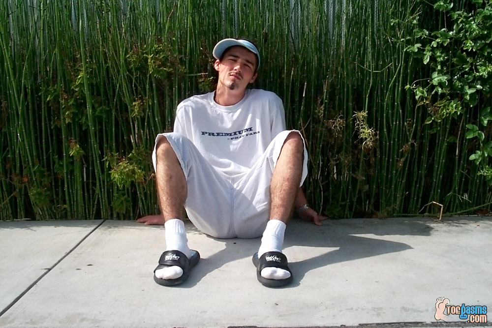 He's wearing shorts, sandals and white socks